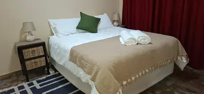 a bedroom with a bed with towels on it at Stay at Wolkeberg in Middelburg