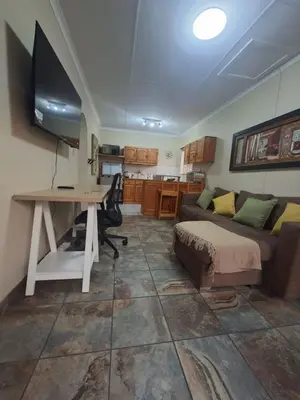 a living room with a desk and a couch and a table at Stay at Wolkeberg in Middelburg