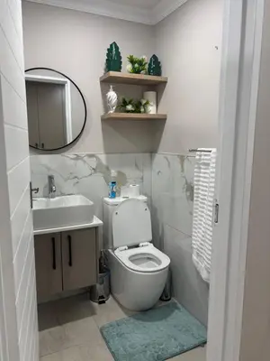 a bathroom with a toilet and a sink and a mirror at Tranquil Stays in Polokwane