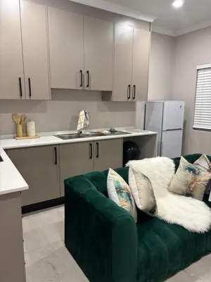 a living room with a green couch in a kitchen at Tranquil Stays in Polokwane