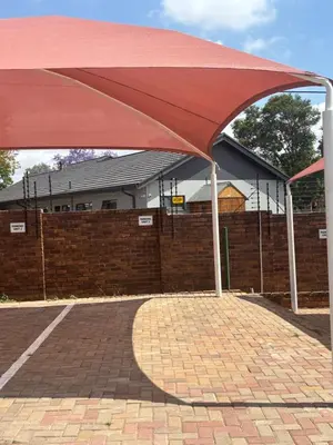 a red umbrella sitting on top of a brick sidewalk at Tranquil Stays in Polokwane