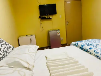 a bedroom with a bed and a tv on the wall at Galaxy Guesthouse Pretoria North in Pretoria