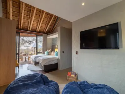 a bedroom with two beds and a flat screen tv at Tintswalo Scops Rest in Klaserie Private Nature Reserve