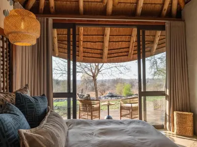 a bedroom with a large window with a view of the outdoors at Tintswalo Scops Rest in Klaserie Private Nature Reserve