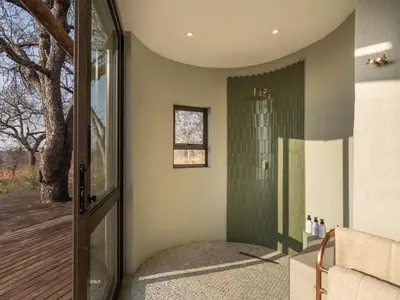a bathroom with a shower with green tiles at Tintswalo Scops Rest in Klaserie Private Nature Reserve