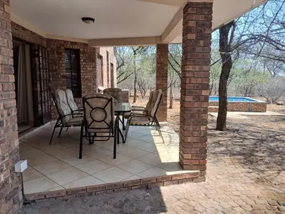 a patio with chairs and a table on a house at Maridadi House in Marloth Park