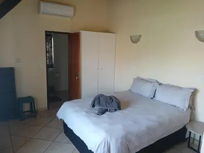 a stuffed elephant laying on a bed in a bedroom at Maridadi House in Marloth Park