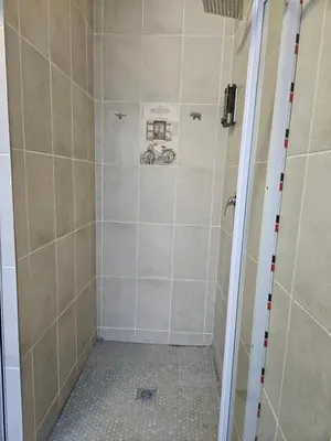 a bathroom with a shower with a tiled floor and a shower at Luxury Meets Convenience Near City & Travel Links in Pretoria