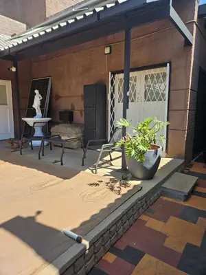 a patio with a bench and a table and a statue at Luxury Meets Convenience Near City & Travel Links in Pretoria