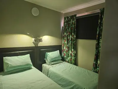 a bedroom with two beds and a window at Luxury Meets Convenience Near City & Travel Links in Pretoria