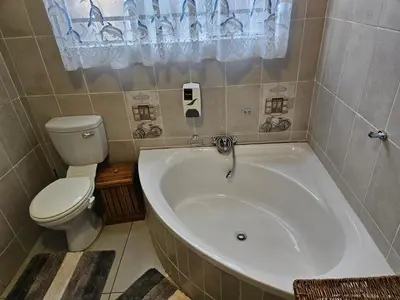 a bathroom with a white tub and a toilet at Luxury Meets Convenience Near City & Travel Links in Pretoria