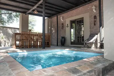 a swimming pool on the patio of a house at Mad Safari Bush Camp in Phalaborwa