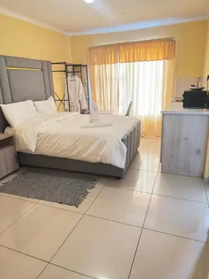 a bedroom with a bed and a large window at The Light Guest House in Midrand