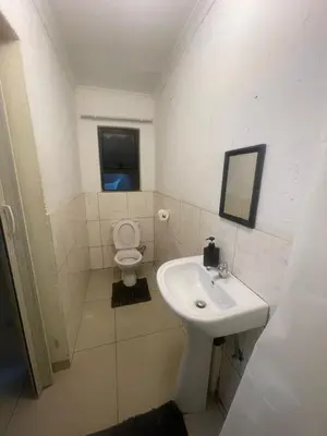 a bathroom with a sink and a toilet at The Light Guest House in Midrand