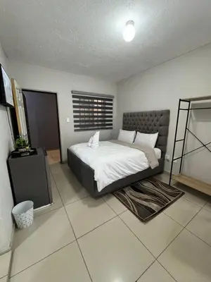 a bedroom with a large bed in a room at The Light Guest House in Midrand