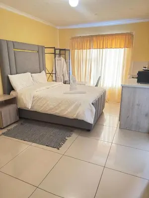 a bedroom with a bed and a large window at The Light Guest House in Midrand