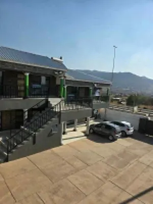 a building with a car parked in a parking lot at House 224 Lodge in Driekop