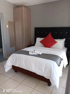a bedroom with a large bed with a cat laying on it at House 224 Lodge in Driekop
