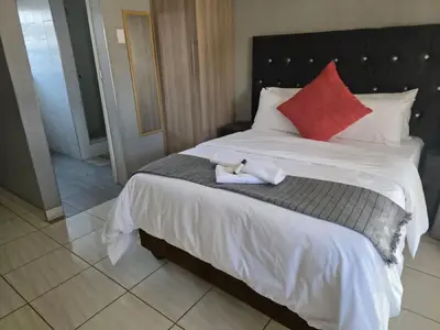 a bed with a stuffed animal sitting on top of it at House 224 Lodge in Driekop