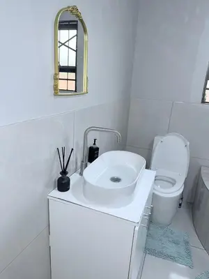 a white bathroom with a sink and a toilet at Country Farm House in Delmas