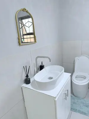 a white bathroom with a sink and a toilet at Country Farm House in Delmas
