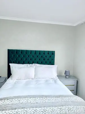 a white bed with a green headboard in a bedroom at Country Farm House in Delmas