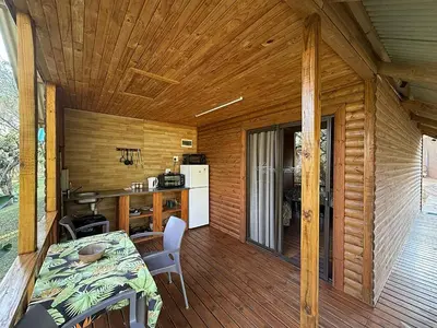 a kitchen and dining room of a log cabin at Leopard Chalets Hippo Waterfront Lodge in Nelspruit