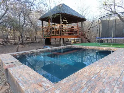 a swimming pool with a gazebo in a yard at Unique Kruger Hide & Spa in Marloth Park