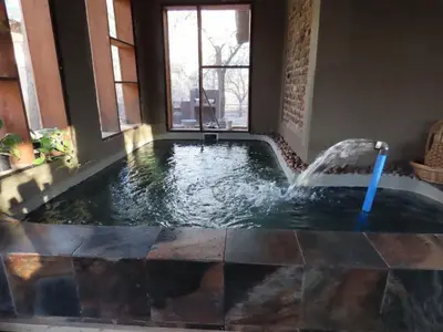 a hot tub in a house with a fountain at Unique Kruger Hide & Spa in Marloth Park