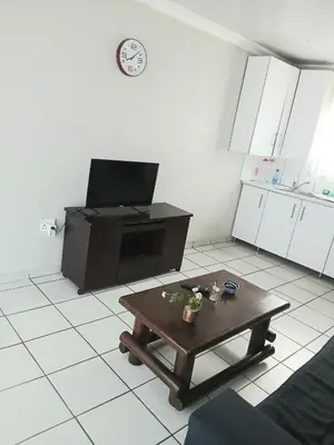 a living room with a coffee table and a tv at Tonta house in Pretoria