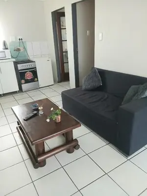 a living room with a black couch and a coffee table at Tonta house in Pretoria