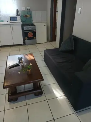 a living room with a black couch and a table at Tonta house in Pretoria