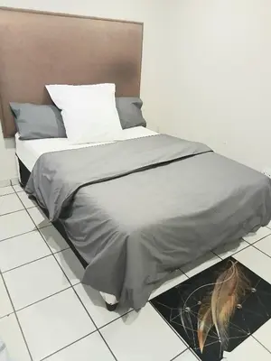 a bed in a room with a person standing on it at Tonta house in Pretoria