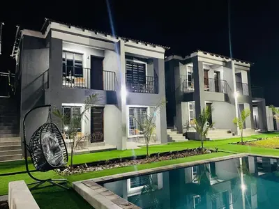 a large house with a swimming pool in front of it at Overflow Accommodation Lodge in Louis Trichardt