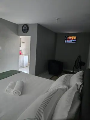 a bedroom with a bed with two towels on it at Ella Guest House in Pretoria