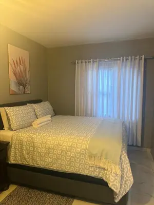 a bedroom with a large bed with a window at Ella Guest House in Pretoria