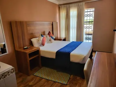 a bedroom with a bed and a window in a room at Villa Hadassa and Spa in Burgersfort