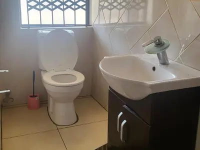 a bathroom with a white toilet and a sink at Villa Hadassa and Spa in Burgersfort