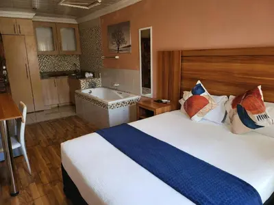a bedroom with a large bed and a bath tub at Villa Hadassa and Spa in Burgersfort
