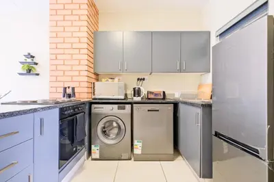 a kitchen with a washer and dryer at Prime Ridge in Midrand