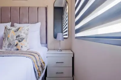a small bedroom with a bed and a window at Prime Ridge in Midrand