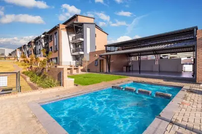 a swimming pool in front of a building at Prime Ridge in Midrand