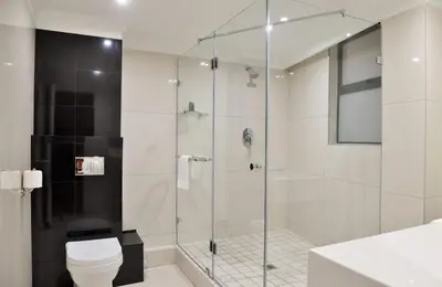a bathroom with a glass shower with a toilet at Hotels Near OR Tambo Airport Booked Easy in Johannesburg