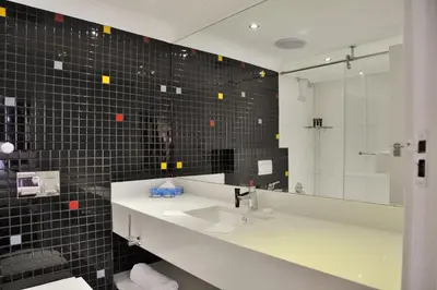 a bathroom with a sink and a mirror at Hotels Near OR Tambo Airport Booked Easy in Johannesburg