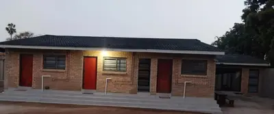 a small brick house with red doors and windows at C-Rane Lodge - E in Phalaborwa