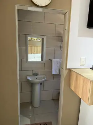 a small bathroom with a sink and a mirror at Zonke Bonke Guest House in Burgersfort