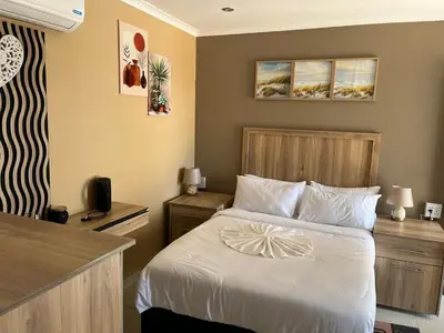 a hotel room with a bed and a kitchen at Zonke Bonke Guest House in Burgersfort