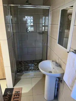a bathroom with a shower and a white sink at Zonke Bonke Guest House in Burgersfort