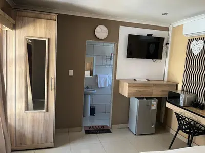 a small kitchen with a sink and a clock on the wall at Zonke Bonke Guest House in Burgersfort