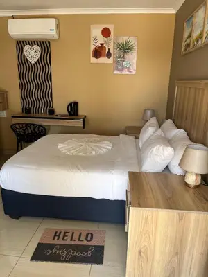 a hotel room with a large bed and a table at Zonke Bonke Guest House in Burgersfort